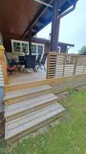 a wooden deck with chairs and tables on a house at Villa Tingsryd nära stranden in Tingsryd