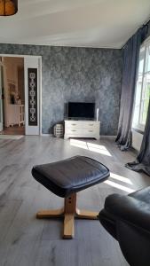 a living room with a bench and a television at Villa Tingsryd nära stranden in Tingsryd
