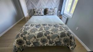 a bedroom with a bed with a blanket and pillows at Bienvenue Chez Mymy! in Sept-Îles