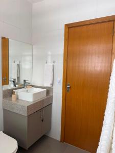 a bathroom with a sink and a wooden door at Casa Aconchegante em Teresópolis in Teresópolis +19 photos