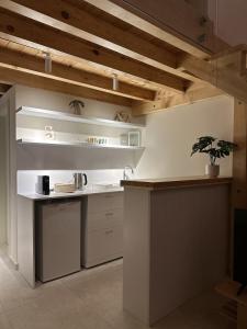 a kitchen with white cabinets and a plant on the counter at CBreeze Guesthouse in Batroûn