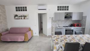 a living room with a couch and a kitchen at Dimora Clorinda in Passo Corese