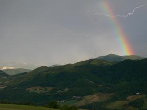 un arco iris en el cielo sobre una montaña en Albergo Stella, en Tolè