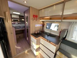 a small kitchen with a sink and a bedroom at Neptun Beach Caravans in Ulcinj