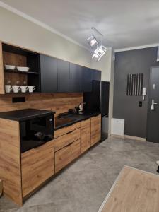 a kitchen with wooden cabinets and a black counter top at Lubanska by Tauron Arena in Zgorzelec