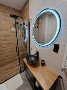 a bathroom with a sink and a shower with a mirror at Lubanska by Tauron Arena in Zgorzelec