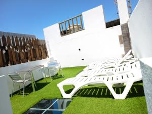 a white bench on the side of a building with grass at Villa de Ingenio JAVAZU in Ingenio