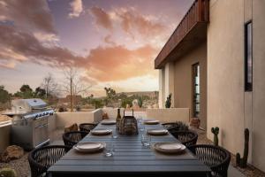 a long table on a patio with a view at Windsong Modern compound w pool spa in Yucca Valley