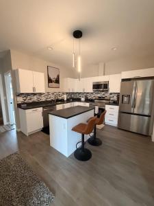 a kitchen with white cabinets and a brown stool at New Modern 2 Bedroom Apartment in Anchorage