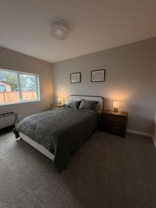 a bedroom with a bed and two lamps on tables at New Modern 2 Bedroom Apartment in Anchorage