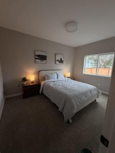 a bedroom with a bed with two lamps and a window at New Modern 2 Bedroom Apartment in Anchorage