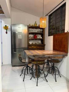 a kitchen with a table and a stainless steel refrigerator at Casinha Rústica in Indaiatuba