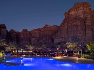 a resort with a large pool in front of a mountain at Shaden Resort Al Ula, Managed by Accor in Al-ʿUla