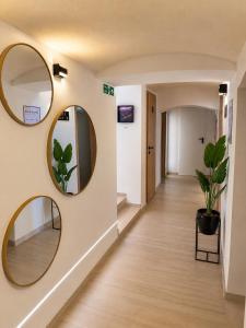 a hallway with two round mirrors on a wall at Urban Base CELJE in Celje