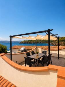 a patio with a table and chairs on a roof at Pareti di mare in Capoliveri