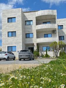 two cars parked in front of a building at بوابة جرش Jarash Gate in Jerash