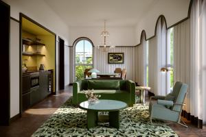 a living room with a green couch and a table at The Warbler in New Orleans