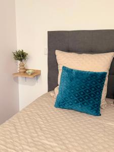 a bed with a blue pillow on top of it at Refúgio d’Aldeia da Serra in Seia