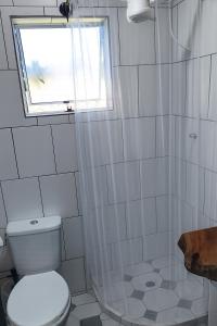 a bathroom with a toilet and a window and a shower at Chalé Romântico Privativo com Lareira e vista para Montanhas in Capela do Alto +12 photos