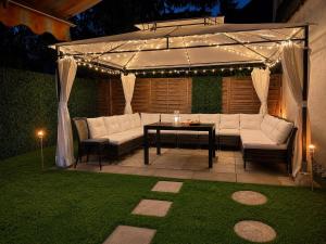 a patio with a couch and a table under a canopy at Hotel Allee 25 in Stuttgart