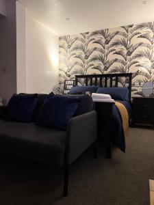 a bedroom with two beds and a couch and a wallpaper at Rutland Point in Uppingham