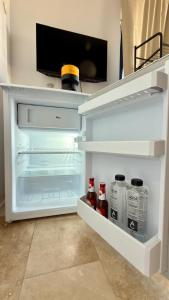 un frigorifero aperto pieno di bevande e bottiglie di soda di Casa IRI - plaja Corbu a Corbu