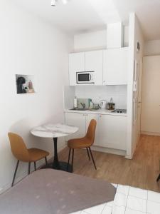 a kitchen with white cabinets and a table and chairs at Apartments Simple Teslina in Zagreb
