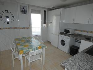 a kitchen with a table and chairs and a washing machine at Vivienda Briviesca La Vega in Briviesca