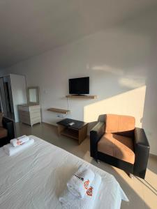 a bedroom with a bed and a couch and a tv at Caesar Resort & SPA - Apartments Studio in Iskele
