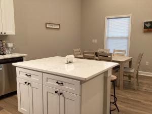 a kitchen with white cabinets and a table with chairs at Pickwick Dreams in Counce +11 photos