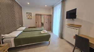 a bedroom with a bed and a flat screen tv at Dimora Clorinda 2 in Passo Corese