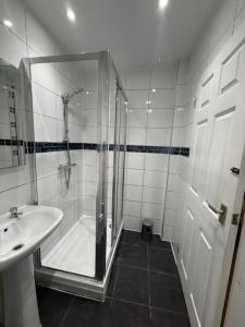 a white bathroom with a shower and a sink at Rutland Point in Uppingham