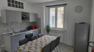 a kitchen with a table with chairs and a refrigerator at Dimora Clorinda 2 in Passo Corese +1 photo
