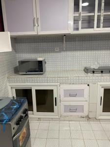 a kitchen with white cabinets and a microwave at Abbe Residence in Bamako