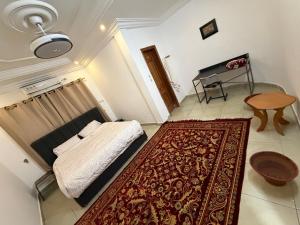 a bedroom with a bed and a rug and a piano at Abbe Residence in Bamako
