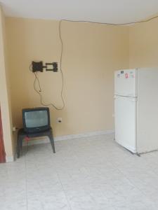 a television with a camera attached to a wall next to a refrigerator at Apartamento centro oriente in Coveñas