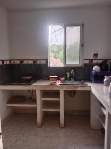 a kitchen with a table and a sink and a window at Apartamento centro oriente in Coveñas