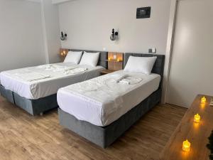 two beds in a room with two tables at Avka Palace in Edirne