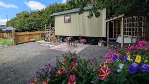 a tiny house in a garden with flowers at The Willows in Scarisbrick