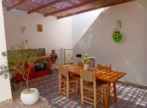 a dining room with a wooden table and chairs at Marrakech Premium Dar Aicha in El Gouassem