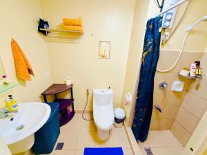 a bathroom with a toilet and a sink and a shower at Avida Condo Lux Studio Unit in Iloilo City +1 photo