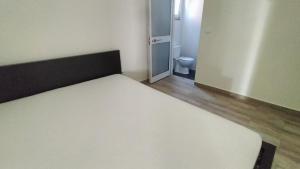 a large bed in a small room with a bathroom at AL - Bino - T3 in Carregosa +2 photos