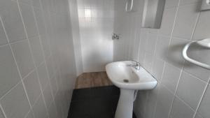 a white bathroom with a sink and a shower at AL - Bino - T3 in Carregosa