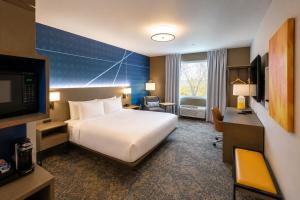 a hotel room with a bed and a desk and a television at Comfort Inn & Suites in Penticton