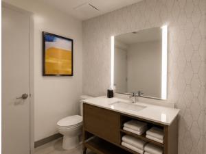 a bathroom with a sink and a toilet and a mirror at Comfort Inn & Suites in Penticton