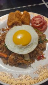 a plate of food with an egg on top of rice at M E N T A R I hostel in Gili Gede
