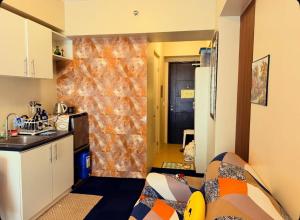 a room with a kitchen with a counter and a kitchen at Avida Condo Lux Studio Unit in Iloilo City