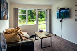 a living room with a couch and a coffee table at Oak Lodge in Taheke