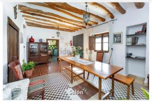 a dining room with a wooden table and chairs at Casa Rural La Saucedilla in Archidona