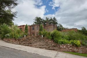 an old brick building with stairs in front of it at Heather Glen Country House in Ainstable
